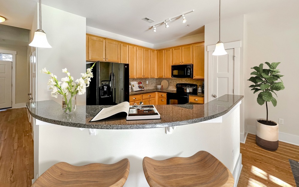 Large kitchen with floating island, floor-to-ceiling cabinets, and appliances at The Townhomes at Chapel Watch Village