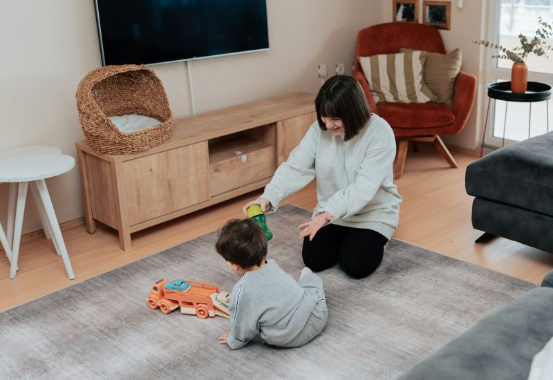 The Townhomes at Chapel Watch Village with a mother and her toddler son playing with toys on the living room floor