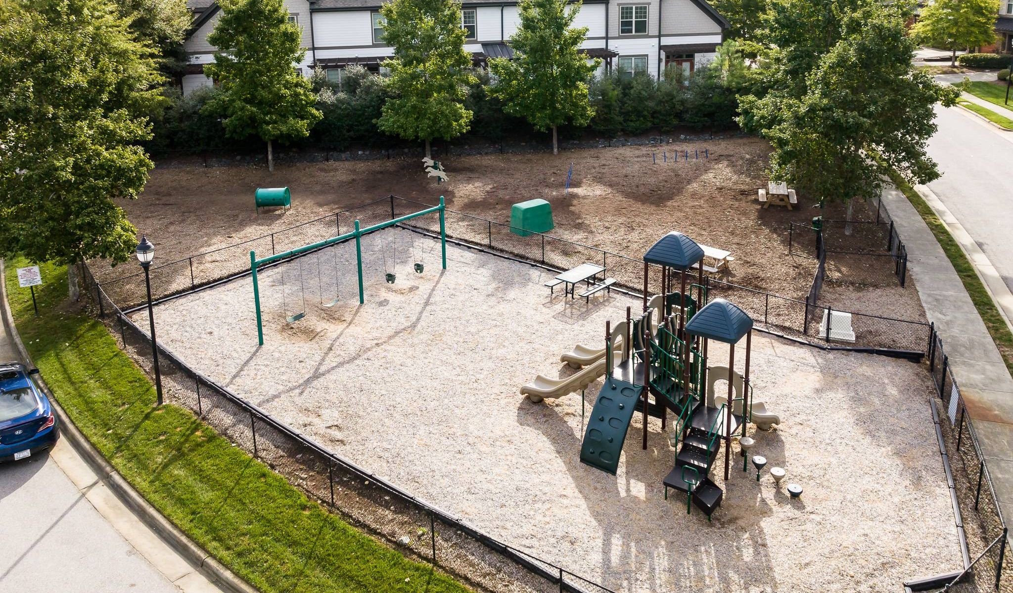 The Townhomes at Chapel Watch Village community amenities with a large fenced playground and dog park